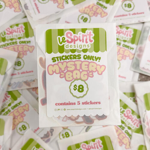 A close-up of a Stickers Only Mystery Pack by LeSpirit Designs ($8) containing 5 stickers, with similar packs scattered in the background.