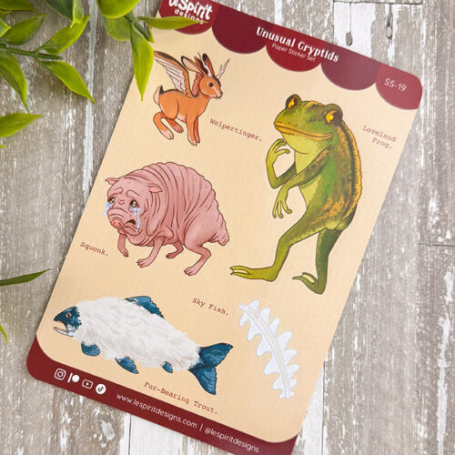 Unusual Cryptids ~ Paper Sticker Sheet features whimsical creatures: a brown Wolpertinger with antlers, green Loveland Toad, pink Squonk, blue and white Sky Fish, and a white Fur-Bearing Trout fishbone.