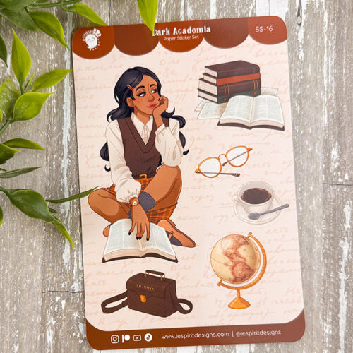 The "Dark Academia ~ Paper Sticker Sheet" features a thoughtful woman with books, glasses, coffee cup, globe, and brown satchel. Green leaves frame the upper left corner for a classic academic vibe.