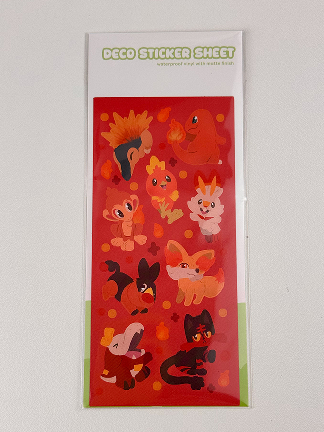 The Fire Starters ~ Deco Sticker Sheet features nine cartoon fire-type animal stickers with flame elements on a red background, labeled as "DECO STICKER SHEET" on the packaging.