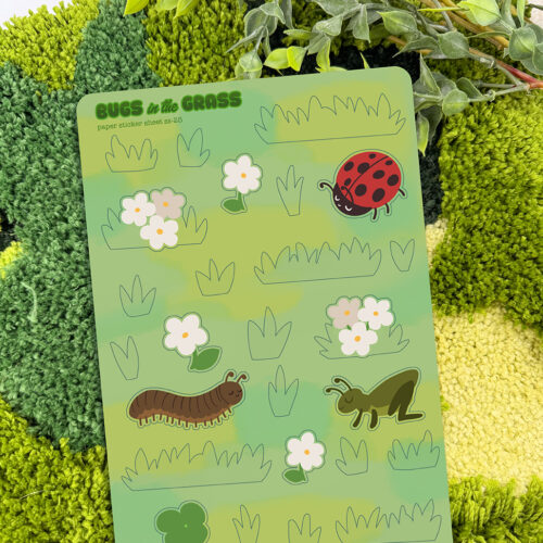 Bugs in the Grass ~ Paper Sticker Sheet features cartoon bugs like a ladybug, centipede, and grasshopper, along with flowers and grass illustrations on textured green paper, with a leafy plant in the background.