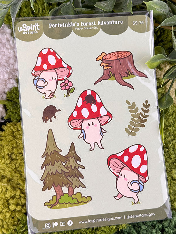 Sticker sheet featuring cute pink mushroom characters, a tree stump, a tree, a small brown animal, and leaves. The background has green yarn and plant leaves. The label reads Periwinkles Forest Adventure..