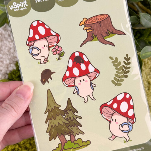 A hand holds a sticker sheet featuring cute mushroom characters, a tree stump, a small black animal, leaves, and trees, with the label Periwinkles Forest Adventure at the top.