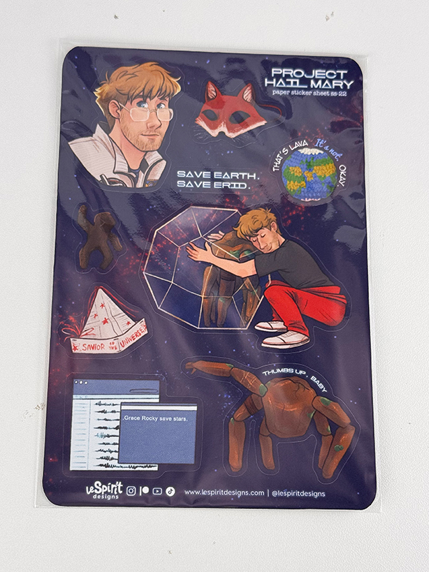 A sticker sheet featuring characters, scientific objects, and phrases from the book Project Hail Mary, including a man, a spider-like alien, a fox mask, and space-themed designs on a starry background.